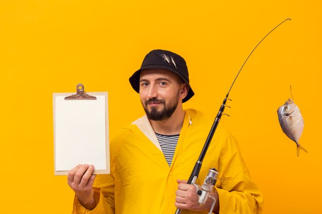 Front view of fisherman holding fishing rod and notepad