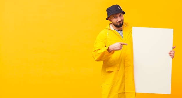 Front view of fisherman pointing at blank placard with copy space