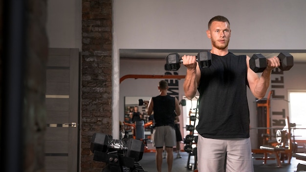 Front view fit man holding dumbbells