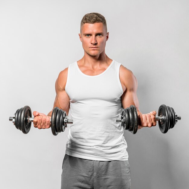 Front view of fit man with tank top using weights