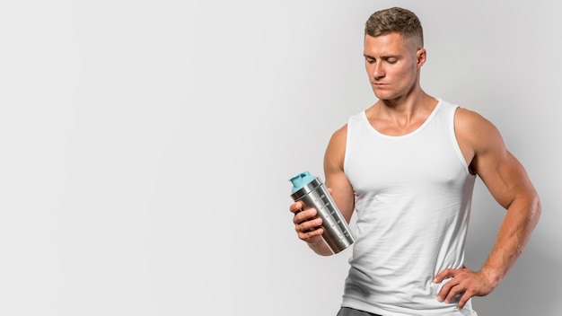 Free photo front view of fit man with water bottle and copy space