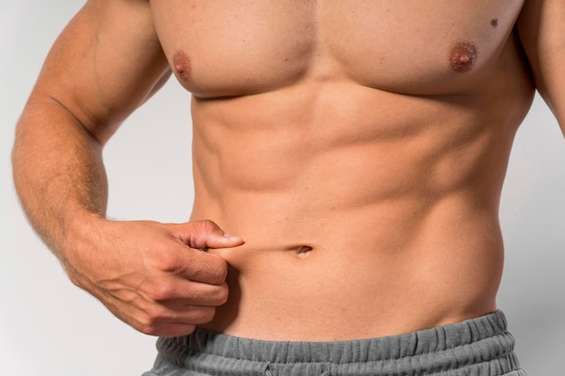 Free photo front view of fit shirtless man showing abs