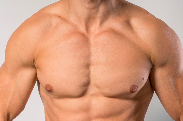Вид спереди подтянутого человека без рубашки, показывающего грудные мышцы