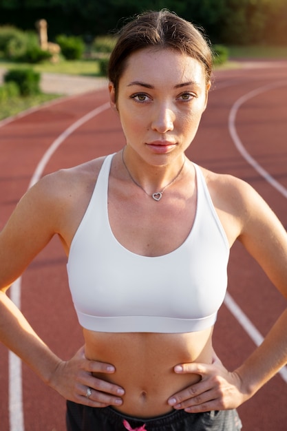 Foto gratuita donna in forma vista frontale sulla pista da corsa