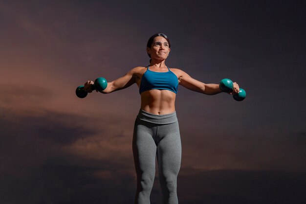 Front view fit woman training with dumbells