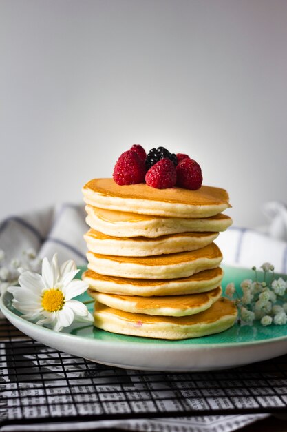 Front view fluffy pancakes tower with raspberries