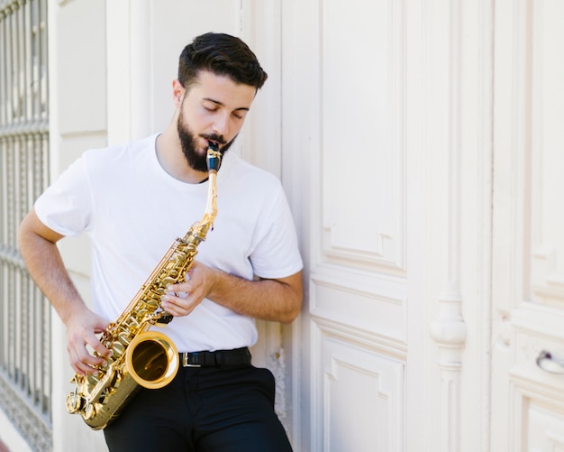 Foto gratuita la vista frontale ha messo a fuoco l'uomo che gioca il sax