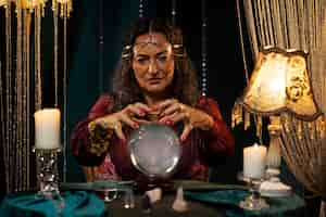 Free photo front view fortune teller with crystal globe