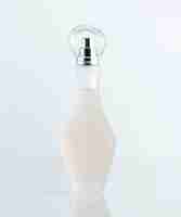 Foto gratuita una fragranza vista frontale trasparente in una bellissima bottiglia progettata sulla scrivania bianca