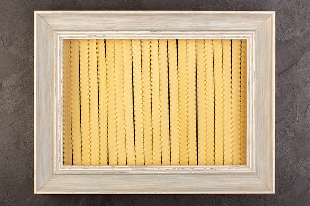 Free photo a front view frame with pasta grey photo frame square formed isolated on the dark background photo food pasta