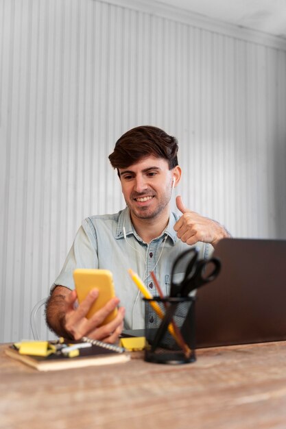 Front view freelancer looking on his phone for a project