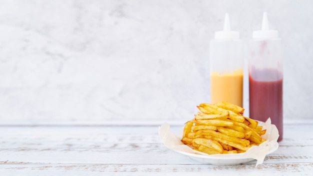 Foto gratuita patate fritte di vista frontale con lo spazio della copia