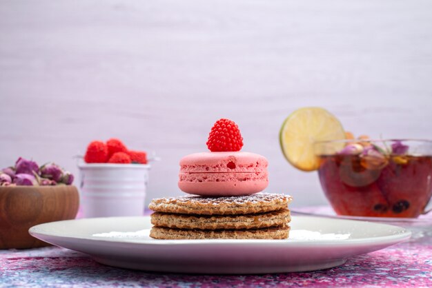 Front view french macarons with cinnamon berries and tea