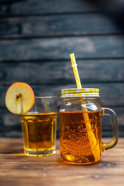 Free photo front view fresh apple juice inside can and glass on a brown wooden desk photo cocktail fruit drink color