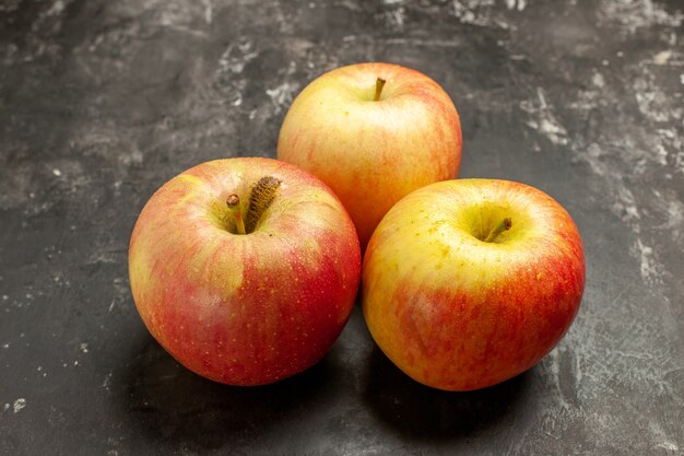Вид спереди свежие яблоки на темных фруктах, спелые витаминные деревья, спелый сок, цветная фотография