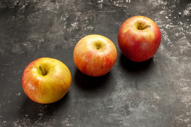 暗い写真のまろやかな果実の熟したビタミン ツリー ジュースの色に並ぶ新鮮なリンゴの正面図