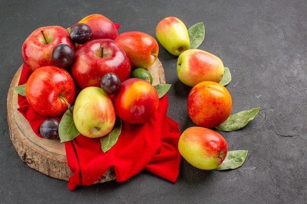 Front view fresh apples  and plums on the dark table juice ripe mellow