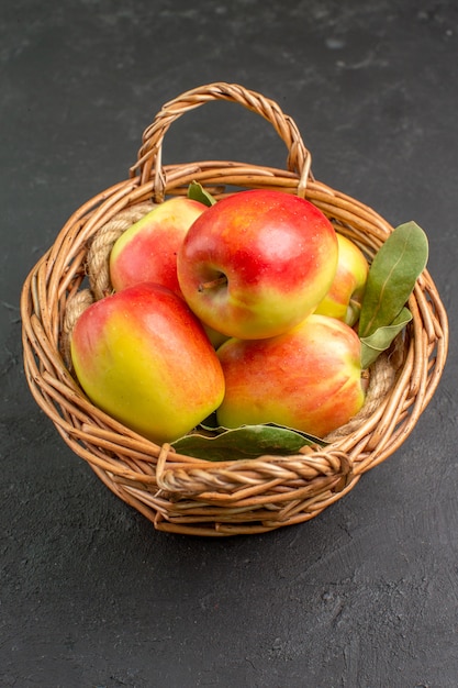 Vista frontale mele fresche frutti maturi all'interno del cesto su pavimento grigio frutta fresca matura