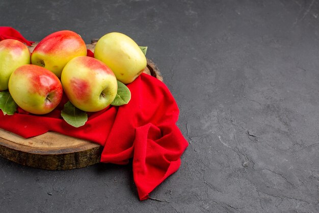 Бесплатное фото Вид спереди свежие яблоки, спелые фрукты на красной ткани и сером полу, свежие спелые фруктовые деревья