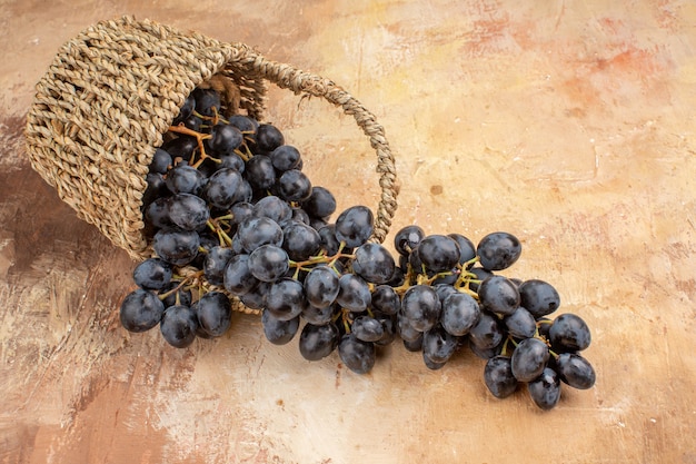 밝은 책상에 있는 바구니 안에 있는 신선한 검은 포도의 전면 보기 잘 익은 과일 와인 부드러운 사진