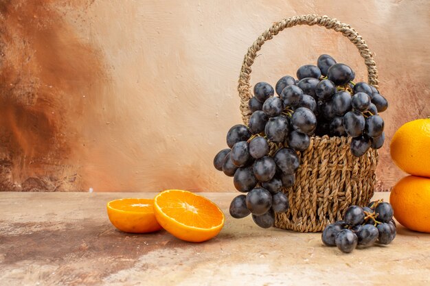Front view fresh black grapes with orange on a light background mellow photo tree ripe fruit vitamine