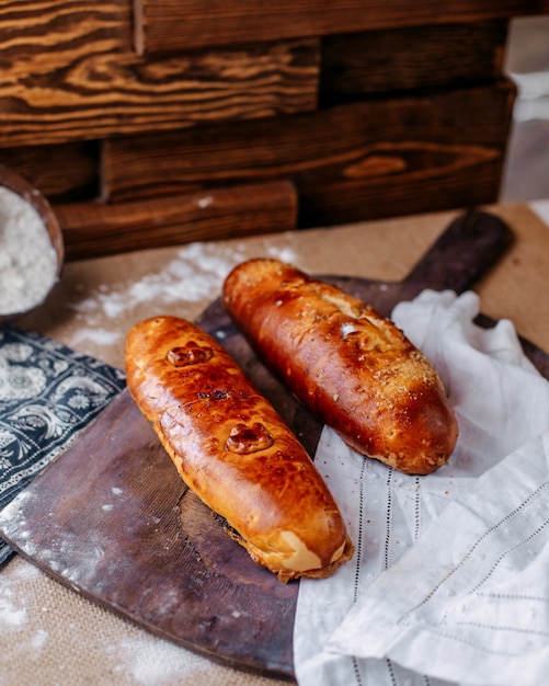 茶色の木製の机と床に正面の焼きたてのパンブラウンおいしい