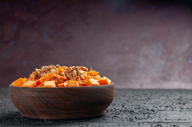 Front view fresh carrot salad grated salad with walnuts and garlic on a dark desk diet salad color nut health