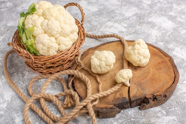 Front view of fresh cauliflower with ropes on light backgruond vegetable food meal raw color