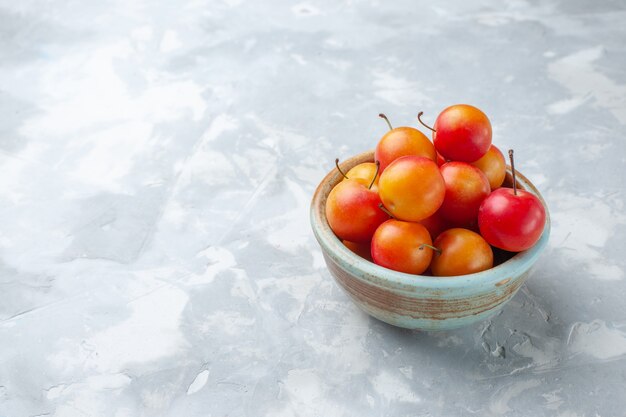 Free photo front view fresh cherry-plums sour and fresh inside pot on light desk fruit sour fresh mellow