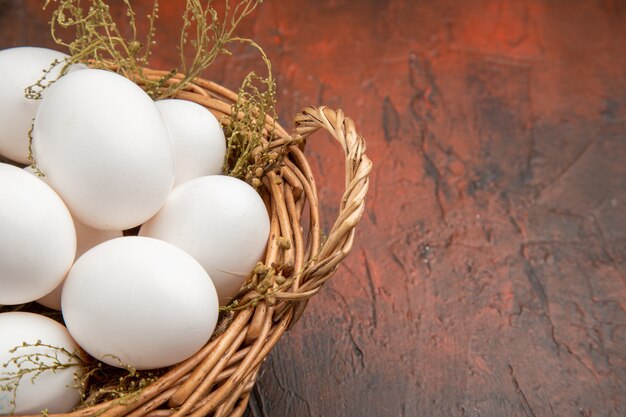 Front view fresh chicken eggs inside basket on dark surface