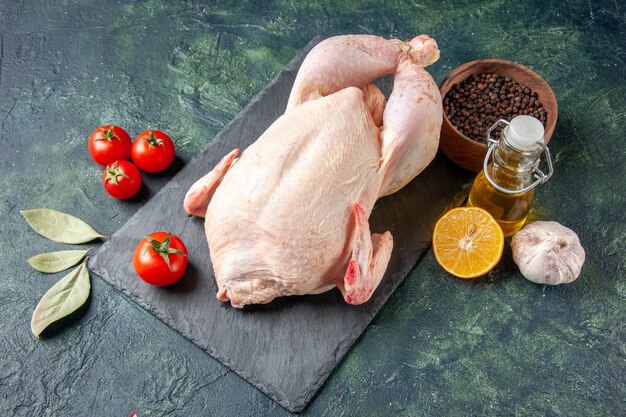 正面図新鮮な鶏肉と赤いトマトの暗いキッチンレストランの食事動物の写真肉の色の食べ物