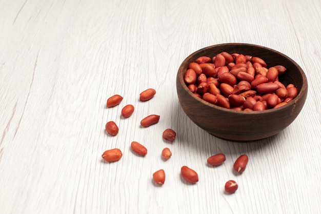 Front view fresh clean peanuts inside plate on light-white desk nut many tree plant shell snack