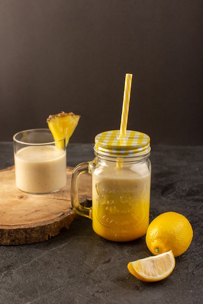 어두운 배경에 레몬과 함께 나무 책상 근처 짚으로 전면보기 신선한 칵테일 맛있는 냉각 음료는 여름 주스를 마실 수