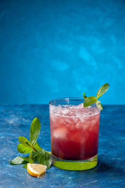正面図青い背景に氷と小さなガラスの中に新鮮なクールなレモネード冷たいジュースドリンク色水フルーツカクテル