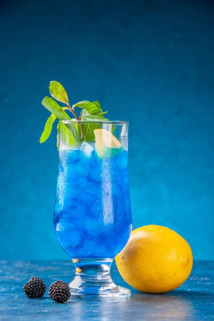 파란색 배경에 얼음이 있는 작은 유리 안에 있는 신선한 시원한 레모네이드 물 차가운 주스 칵테일 색상 바 음료 과일