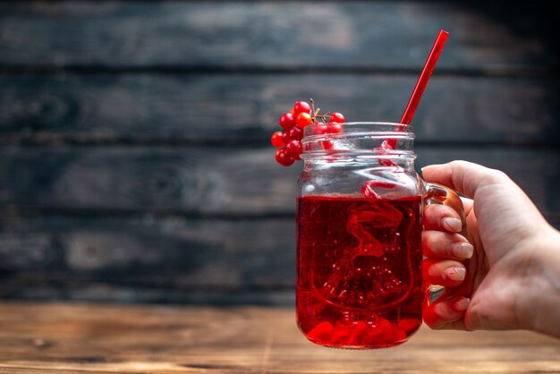 Вид спереди свежий клюквенный сок внутри банка с соломкой на темном баре фруктовый коктейль цветной напиток ягода