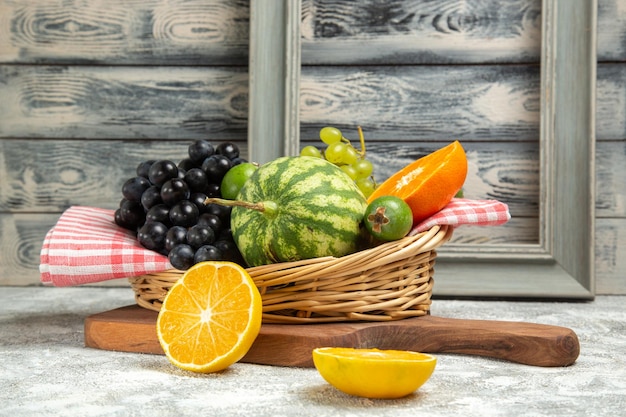 Foto gratuita vista frontale fresca uva scura con arancia e anguria su sfondo bianco frutta matura dolce vitamina albero fresco