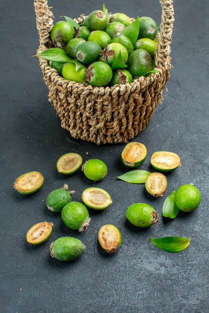 Front view fresh feijoas in basket on dark surface