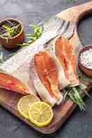 Бесплатное фото Вид спереди ломтики свежей рыбы с лимоном на темном фоне цвет еды вода мясо еда океан ужин морепродукты здоровье