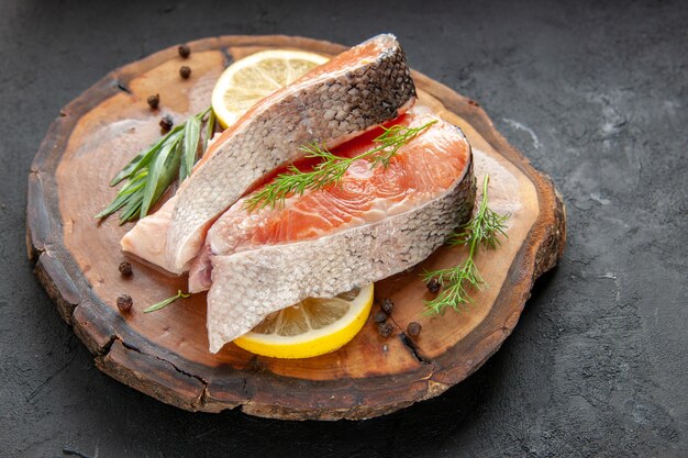 正面図新鮮な魚のスライスとレモンスライスのダークディッシュカラー食品肉シーフード写真生