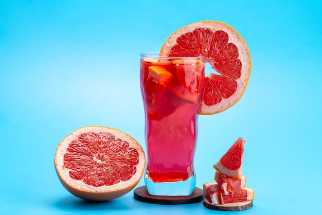 Свежий фруктовый коктейль, вид спереди, с кусочками свежих фруктов, ледяное охлаждение на синем, питьевой коктейль, фруктовый цвет