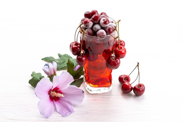 A front view fresh fruit cocktail with fresh red cherries ice cooling on white, drink juice cocktail fruit color