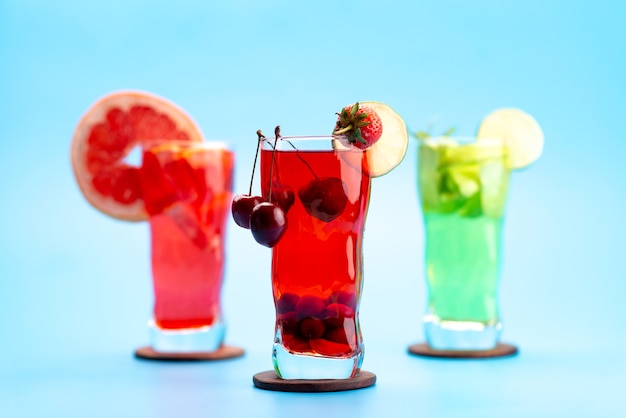 Foto gratuita una vista frontale cocktail di frutta fresca con fette di frutta fresca raffreddamento a ghiaccio sul blu, bere succo di frutta cocktail di colore