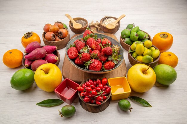 Вид спереди композиция из свежих фруктов на белом фоне фото цветная ягода цитрусовое дерево здоровья спелые фрукты вкусно