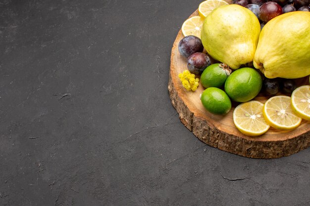 Front view fresh fruits grapes lemon slices plums and quinces on dark background fresh fruits ripe plant tree