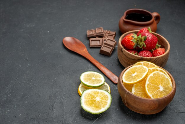 Front view fresh fruits strawberries and lemons on gray background