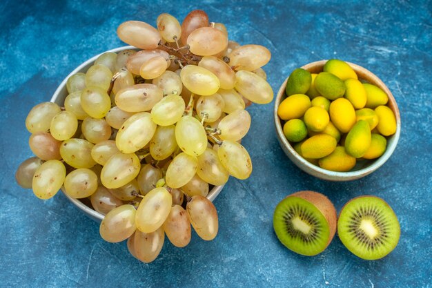 Vista frontale uva fresca all'interno del piatto su succo blu frutta matura colore dolce foto