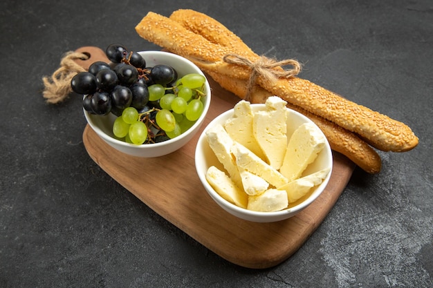 Вид спереди свежий виноград с сыром и хлебом на темном фоне фрукты спелое спелое дерево витамин пищевое молоко
