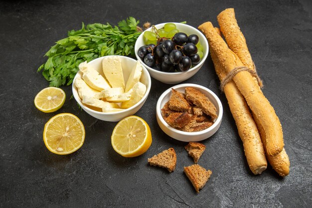 Front view fresh grapes with white cheese greens and lemon slices on dark background meal breakfast dish milk fruit