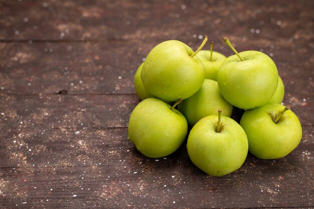 Вид спереди свежие зеленые яблоки, изолированные на деревянном столе
